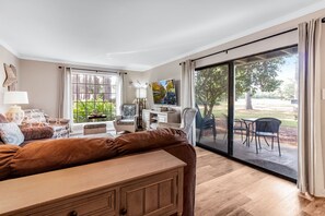 A spacious living room with a large sliding glass door leading to an outdoor patio area. - Seascape Resort Villa | Golden Pond Pool | Minutes to the Beach! (Miramar Beach)