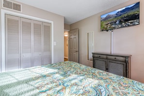 A bedroom with a bed, a dresser, a television mounted on the wall, and a closet. - Seascape Resort Villa | Golden Pond Pool | Minutes to the Beach! (Miramar Beach)
