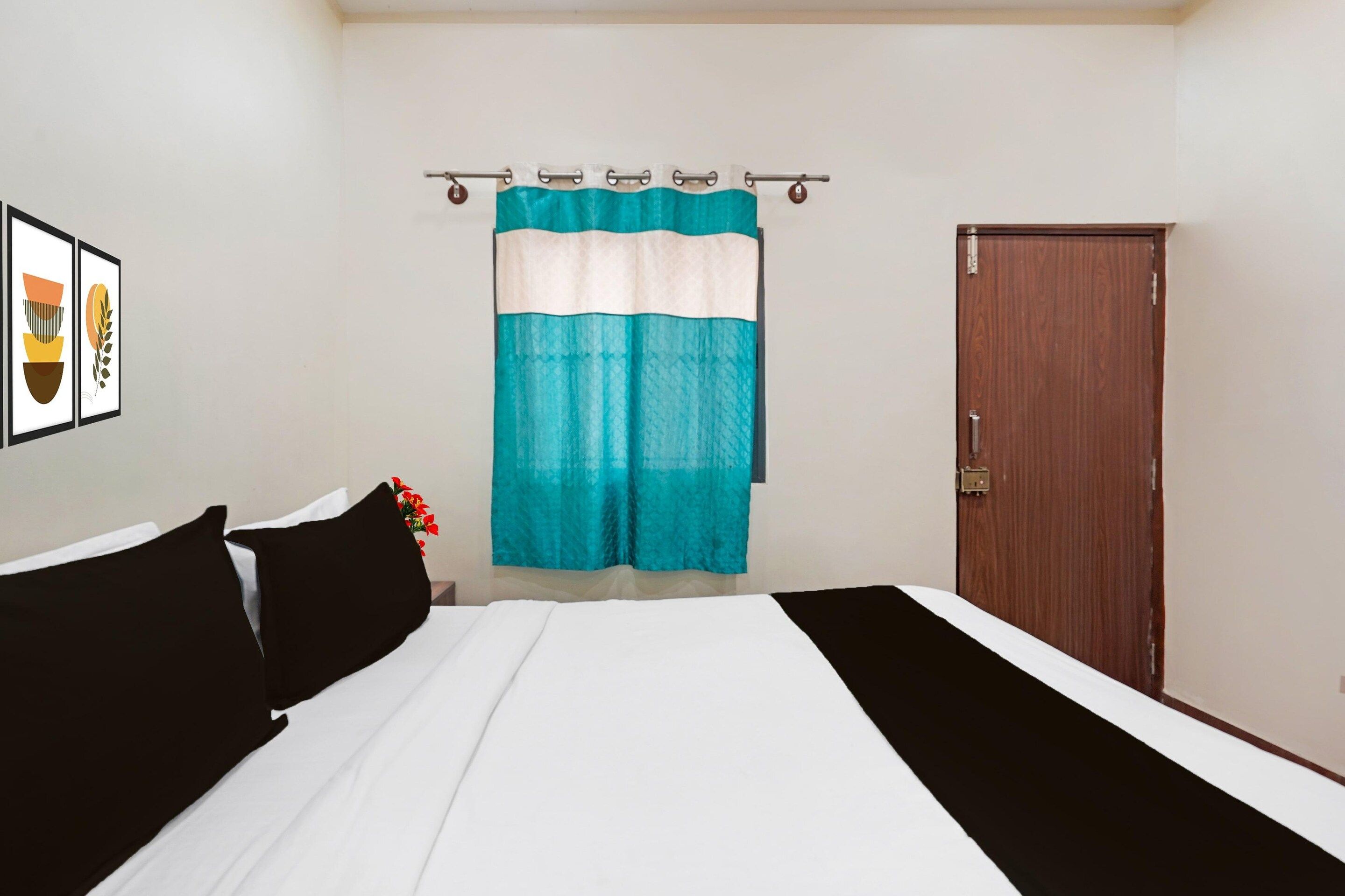 A bedroom with a bed, a door, and a curtain.