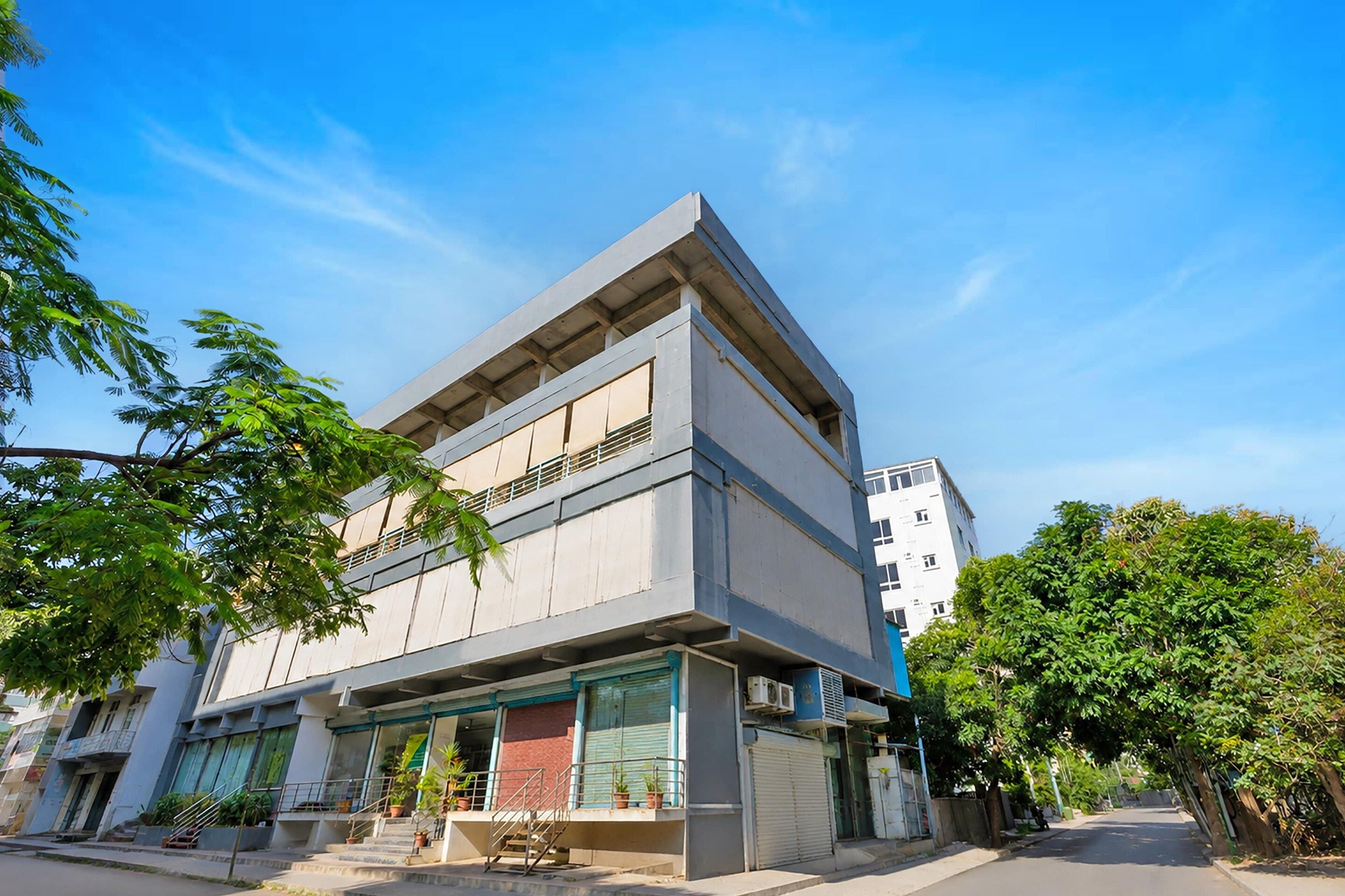 A multi-story building with a flat roof and large windows.
