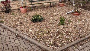 Un edificio con un muro de piedra y un banco de madera al frente.