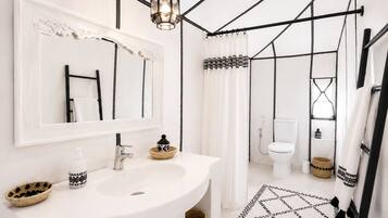 Separate bathtub and shower, towels, shampoo, toilet paper