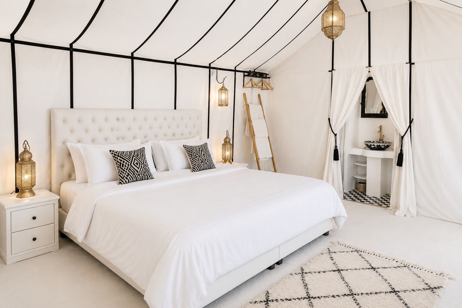 A bedroom with a large bed, bedside tables, a hanging lantern, a white curtain, and a small bathroom with a sink and mirror.