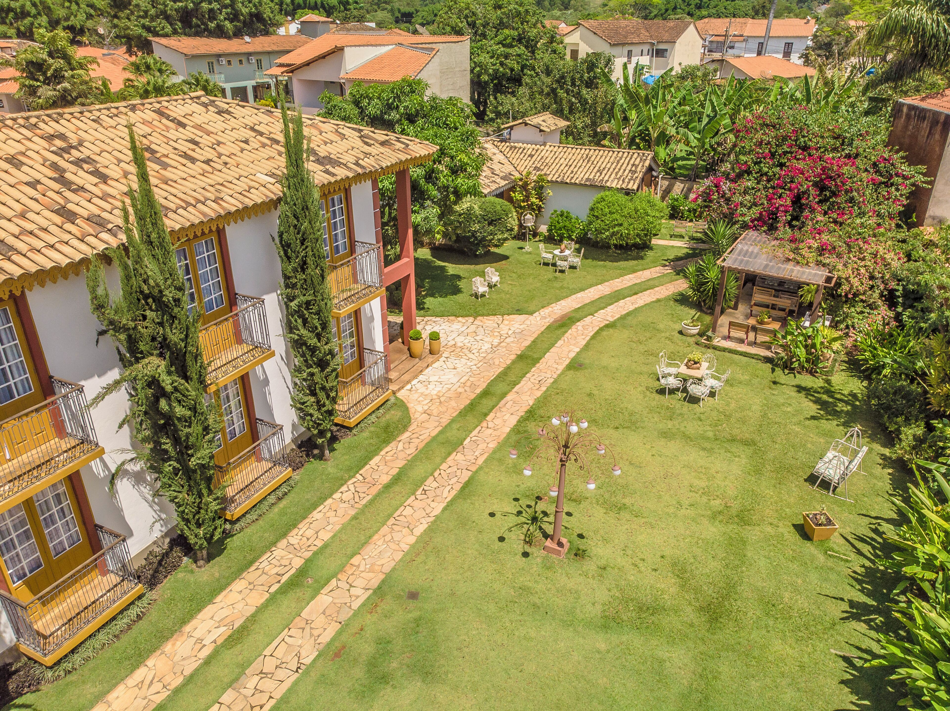 Um bairro residencial com várias casas, um jardim bem cuidado e um caminho pavimentado.