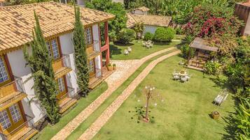 Um bairro residencial com várias casas, um jardim bem cuidado e um caminho pavimentado.