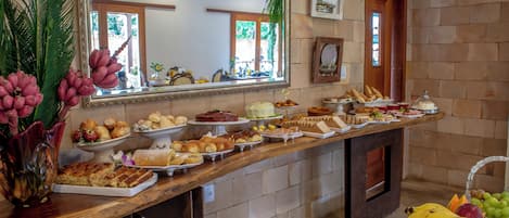 A buffet table with various food items and a mirror reflecting the room.