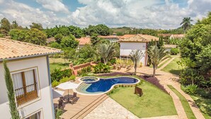 Una propiedad residencial con piscina, mobiliario exterior y un jardín bien cuidado.
