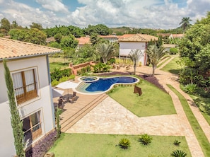 A residential property with a swimming pool, outdoor furniture, and a well-maintained garden.