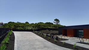 A modern building with a concrete pathway leading to a wooden door. - RR Suites (Madalena)