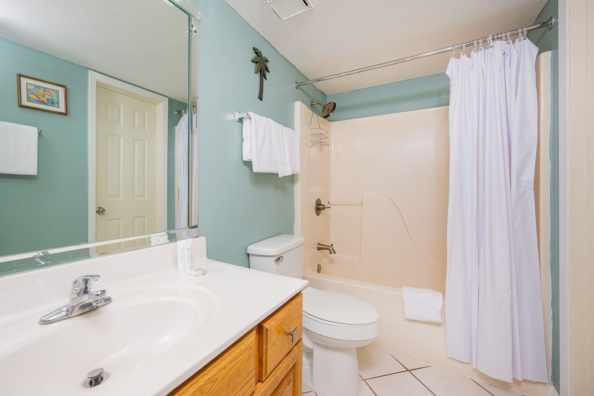 A bathroom with a white sink, toilet, and shower area.