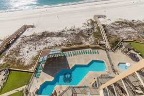 Un resort con una piscina grande, playa y una torre de salvavidas.