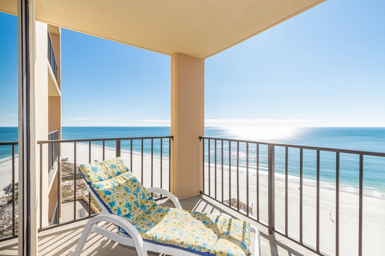 A balcony with a view of the beach and ocean.