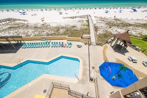 A resort with a swimming pool, beach umbrellas, and a beach view. - Phoenix I 1044 1 Bedroom Condo (Orange Beach)