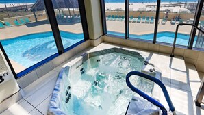 Un jacuzzi con vista a la playa y la piscina.