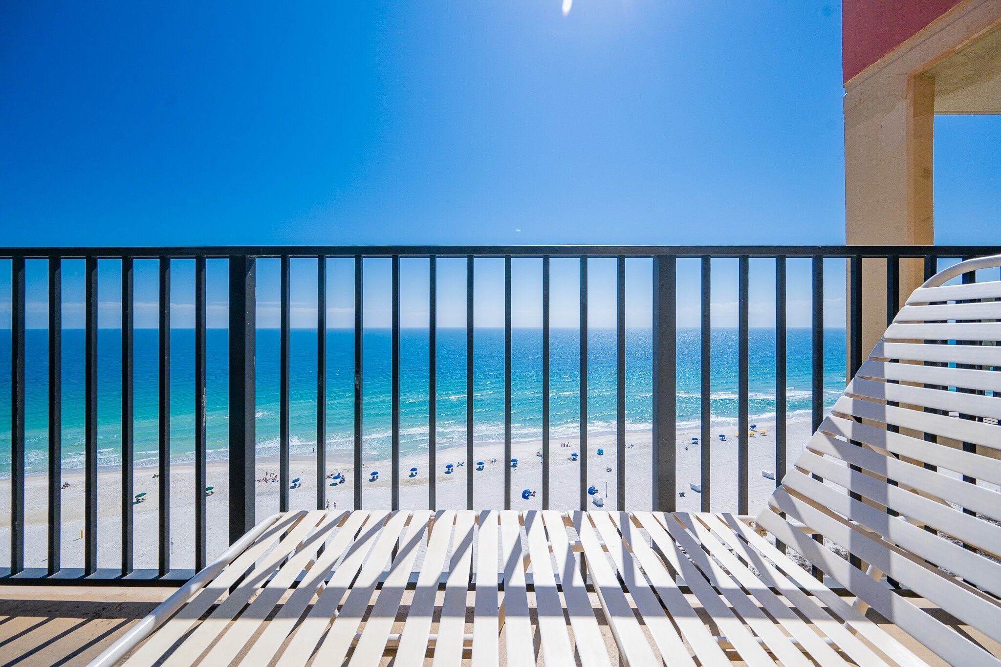 A balcony with a view of a beach and the ocean.