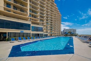A swimming pool with lounge chairs and a 'No Diving' sign, surrounded by a high-rise building with balconies. - Phoenix V 1511 1 Bedroom Condo (Orange Beach)