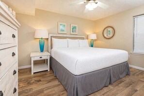 A bedroom with a bed, nightstands, a dresser, and a ceiling fan. - Phoenix V 414 1 Bedroom Condo (Orange Beach)
