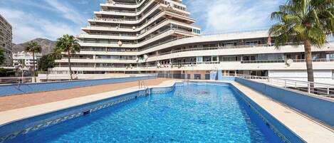 A multi-story hotel with a swimming pool.