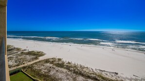 A beach with a clear sky, sandy shore, and a few people. - Phoenix V 1111 1 Bedroom Condo (Orange Beach)