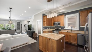 A modern kitchen with wooden cabinets, stainless steel appliances, and a central island. - Beautiful, Spacious 3BR Ukrainian Village Home w/ Deck, Garage & Room for Groups (Chicago)