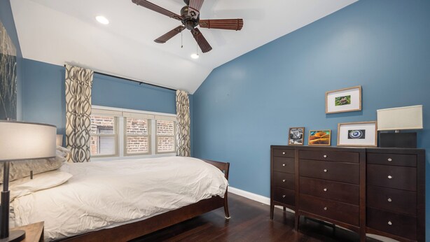 A bedroom with a bed, a dresser, a ceiling fan, and a window with curtains. - Beautiful, Spacious 3BR Ukrainian Village Home w/ Deck, Garage & Room for Groups (Chicago)