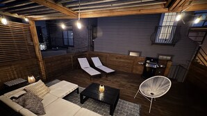 A cozy outdoor seating area with a sofa, lounge chairs, and a grill. - Beautiful, Spacious 3BR Ukrainian Village Home w/ Deck, Garage & Room for Groups (Chicago)