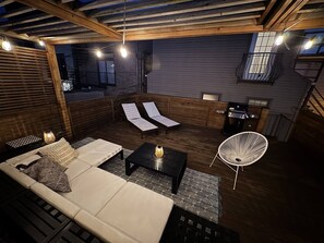 A cozy outdoor seating area with a sofa, lounge chairs, and a grill. - Beautiful, Spacious 3BR Ukrainian Village Home w/ Deck, Garage & Room for Groups (Chicago)
