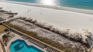 An aerial view of a beach with a swimming pool and lounge chairs. - Phoenix V 1207 1 Bedroom Condo (Orange Beach)