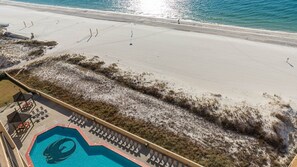 An aerial view of a beach with a swimming pool and lounge chairs. - Phoenix V 1207 1 Bedroom Condo (Orange Beach)