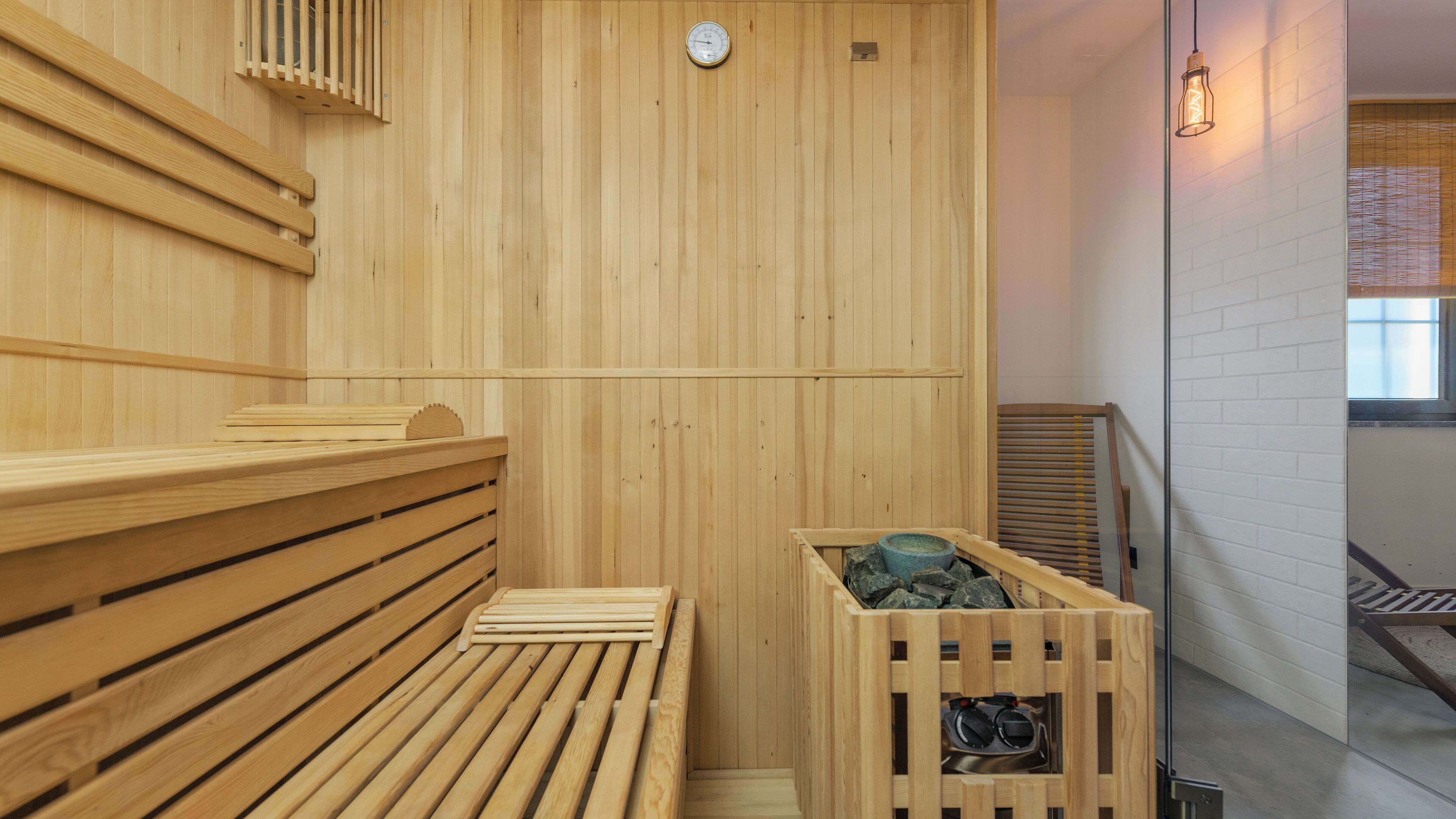 A wooden sauna with benches and a stone basin.