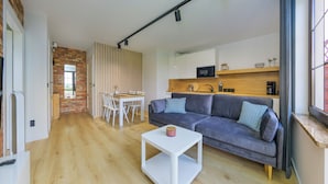 Un espacio habitable moderno con sofá, mesa de comedor y zona de cocina.