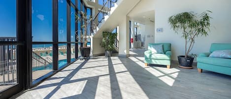 Un balcón amplio con vista a la piscina, arquitectura moderna y zonas de estar cómodas.
