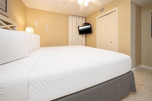 A hotel room with a bed, a television mounted on the wall, and a ceiling fan. - Phoenix V 307 1 Bedroom Condo (Orange Beach)