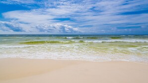 Ein Strand mit Wellen und blauem Himmel.