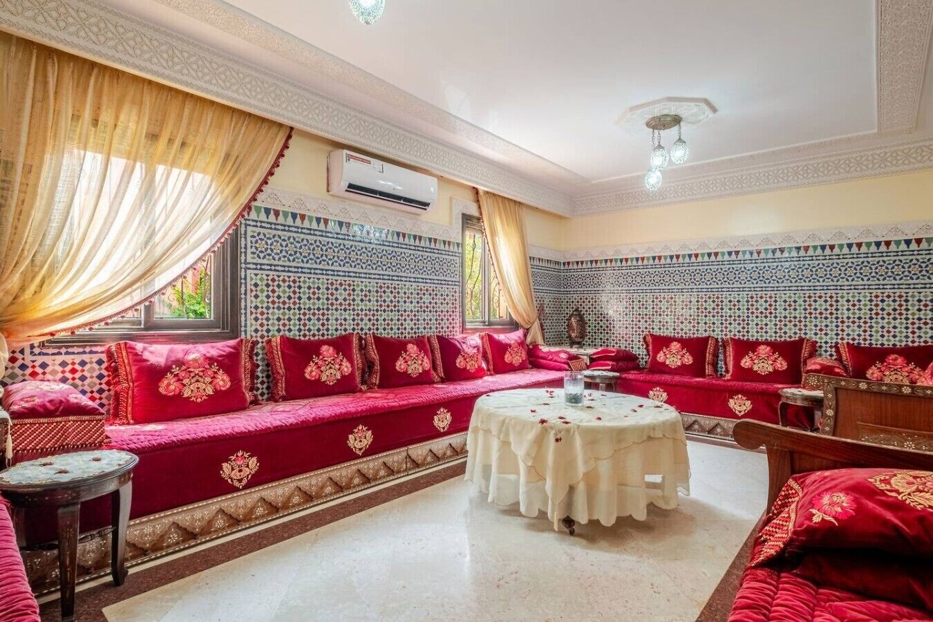 A traditional room with patterned walls, a sofa set, and a round table.