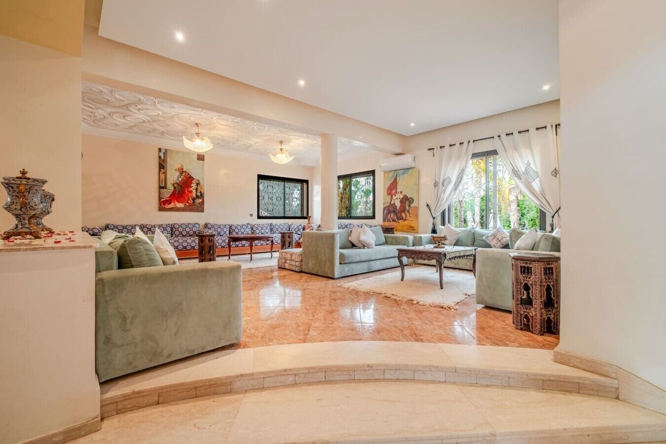 A spacious living area with a sofa set, a coffee table, and decorative items.