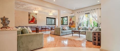 A spacious living area with a sofa set, a coffee table, and decorative items.