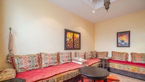 Un salon comprenant un ensemble de canapés, une petite table et deux tableaux accrochés au mur.