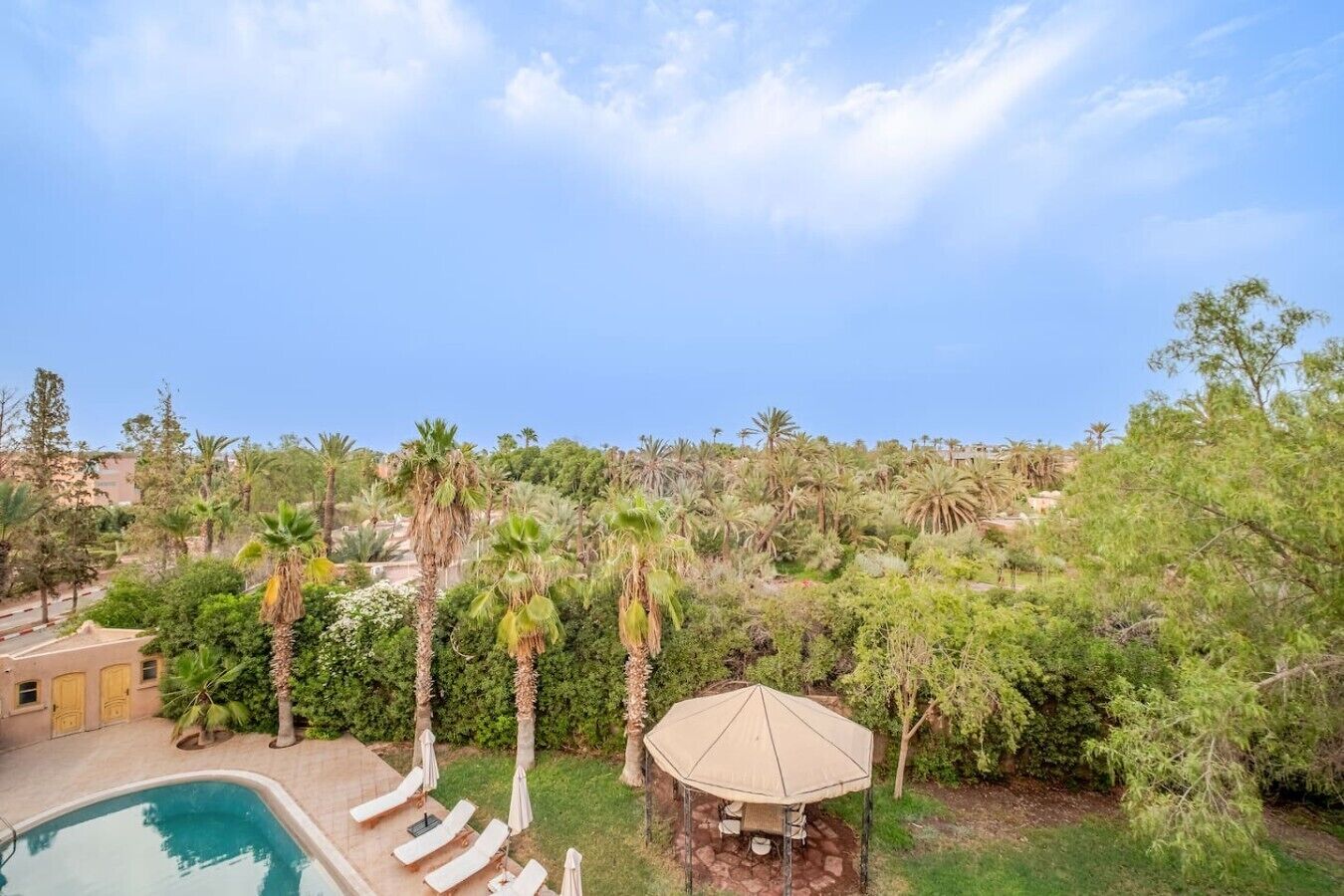 A pool area with lounge chairs and a gazebo.