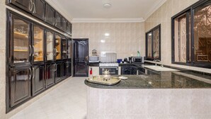 Une cuisine moderne avec des meubles de couleur sombre, un îlot central et un four à micro-ondes.