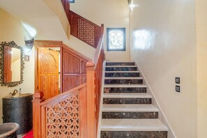 A staircase with marble steps, wooden railings, and a decorative door. - Villa Piscine / Hammam / 10 min de Centre (Marrakesh)