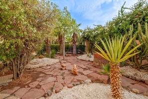 A garden with a stone pathway, various plants, and a palm tree. - Villa Piscine / Hammam / 10 min de Centre (Marrakesh)