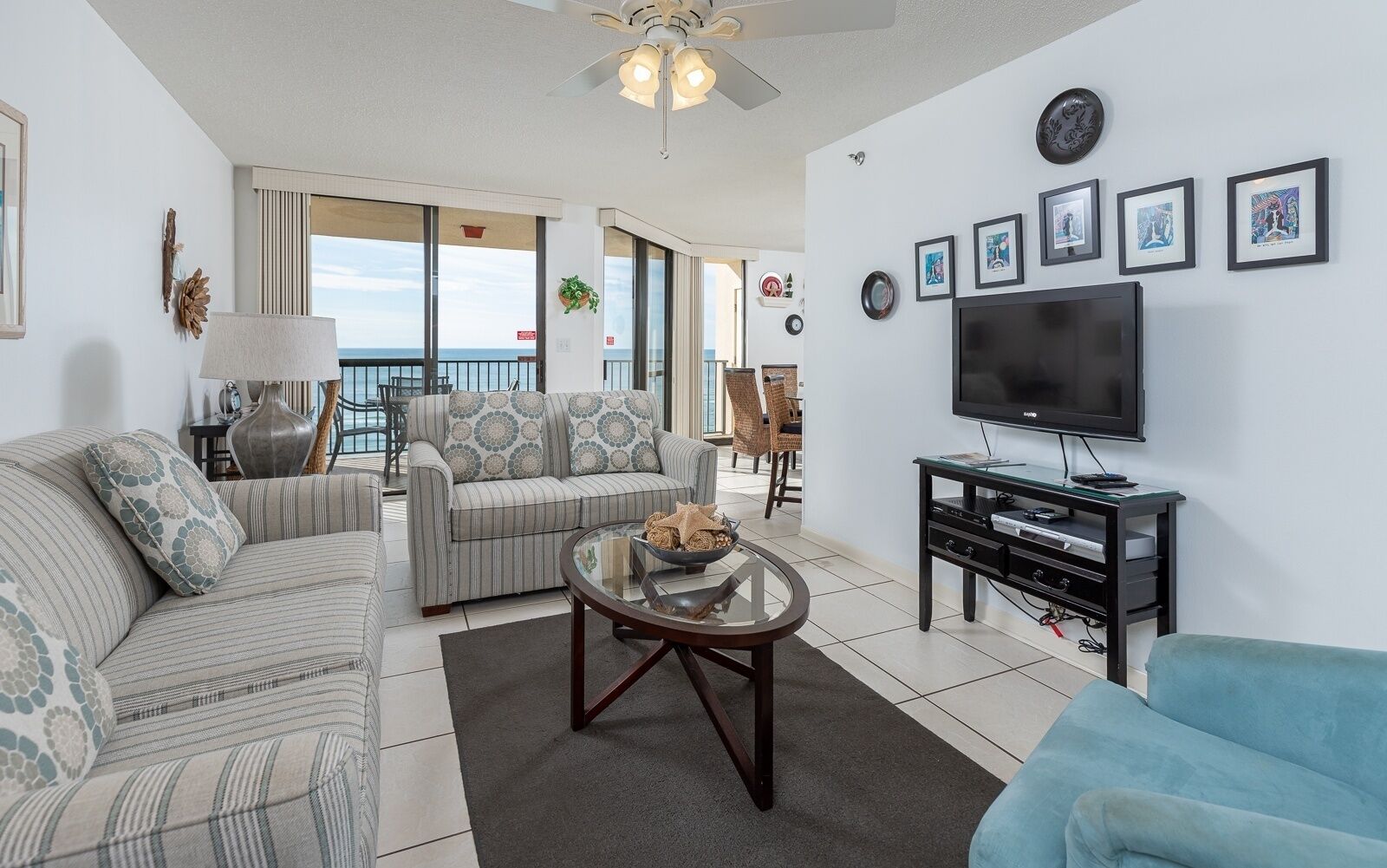 A living room with a sofa, armchair, coffee table, and a TV stand.