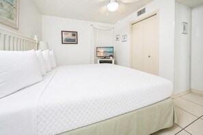 A hotel room with a large bed, a television, and a wardrobe. - Phoenix V 814 1 Bedroom Condo (Orange Beach)