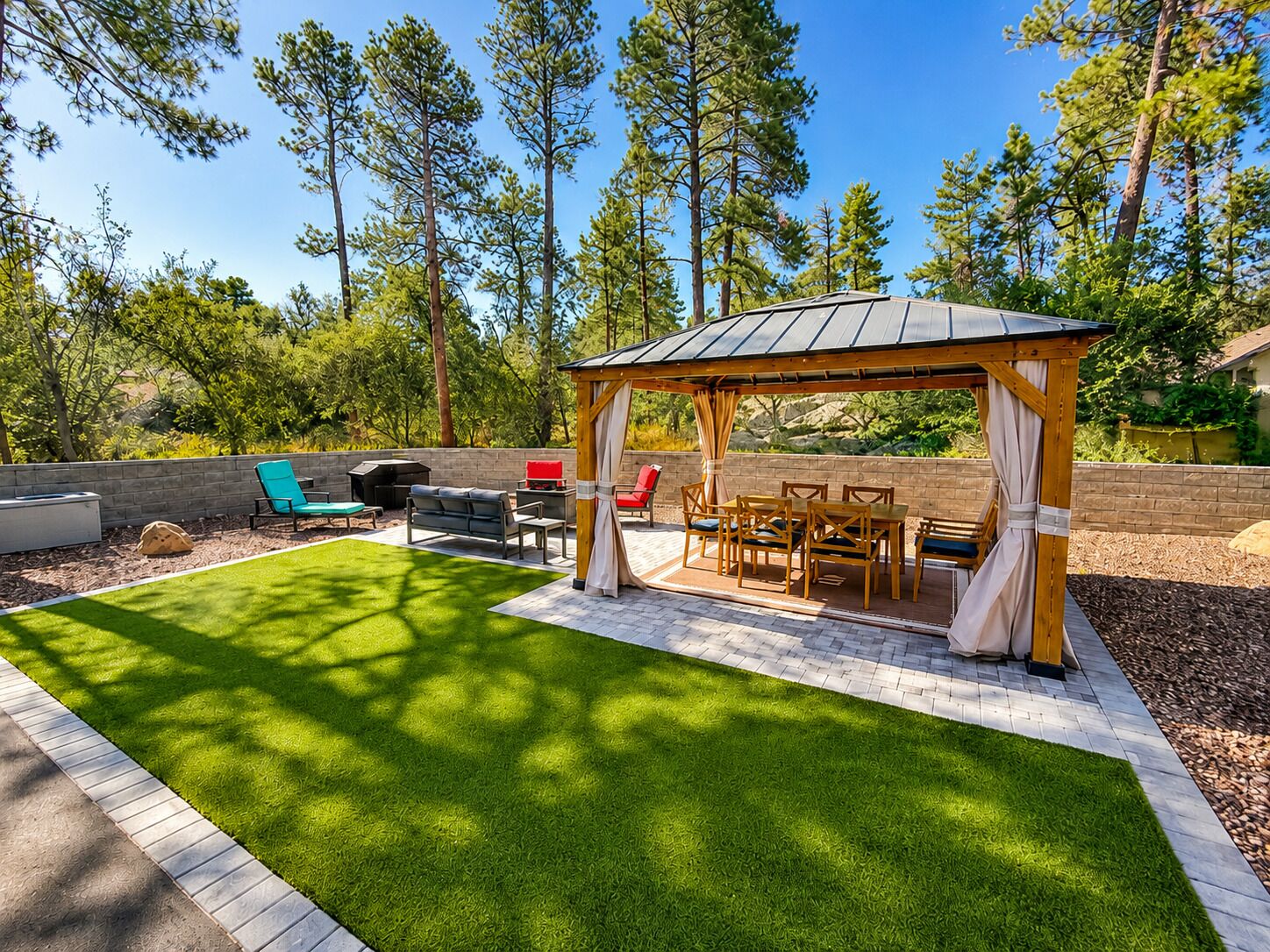 Een overdekt terras met een barbecue en tuinmeubilair.