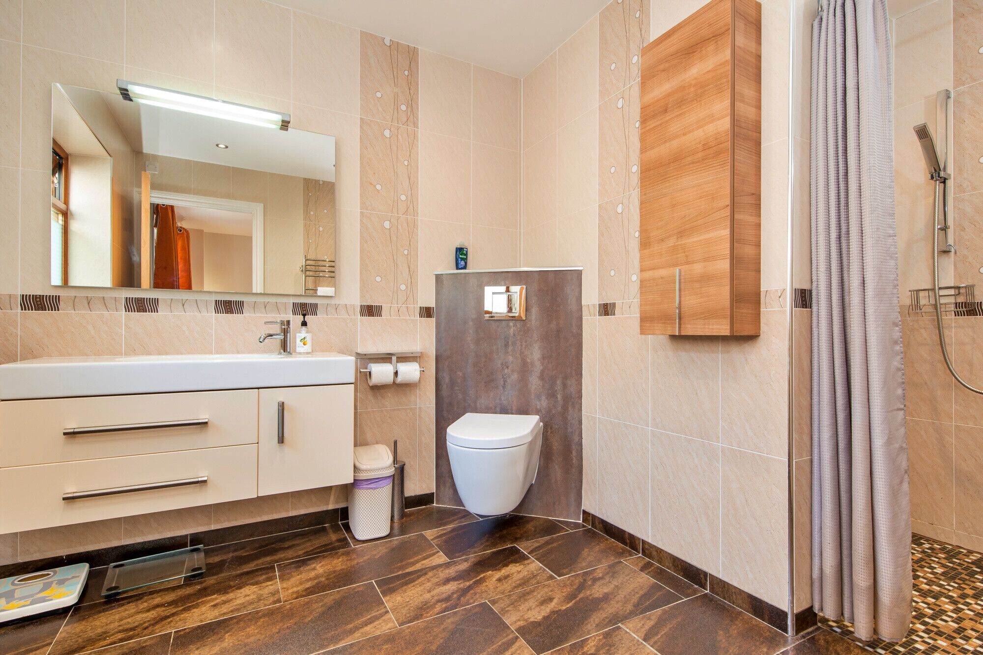 A modern bathroom with a shower, toilet, and vanity.