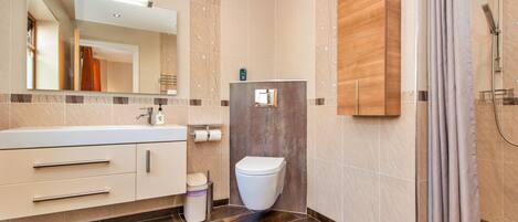 A modern bathroom with a shower, toilet, and vanity.