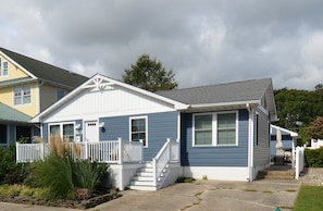 A two-story house with a front porch, a garage, and a covered patio area. - Downtown Rehoboth Beach Cozy Beach Getaway! (Rehoboth Beach)