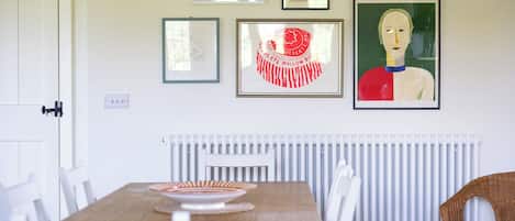Un coin repas avec une table, des chaises et un radiateur.
