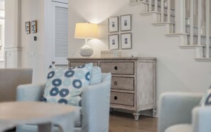 A room with a wooden dresser, a lamp, and framed pictures on the wall. - 287 W Lake Forest Dr - WaterColor Home (Santa Rosa Beach)